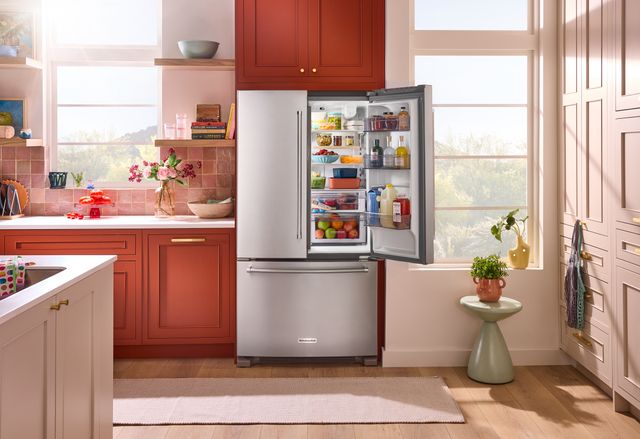 Front view of a modern kitchen with an opened KitchenAid refrigerator