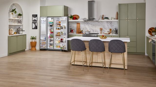 Front view of a modern kitchen with an opened side by side KitchenAid panel refrigerator