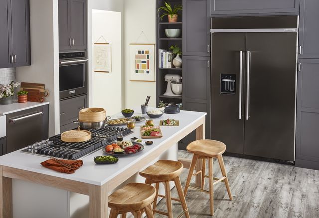 view of a modern kitchen with grey cabinets and black stainless steel KitchenAid appliances