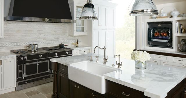 Front view of a modern kitchen with La Cornue appliances and a white farmhouse kitchen sink