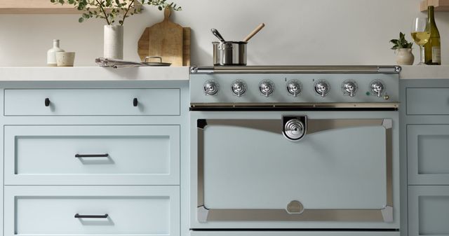 Front view of a light blue La Cornue range with matching cabinetry