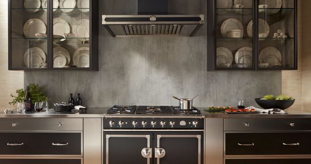 front view of a large luxury grey modern kitchen with a black la cornue range and range hood