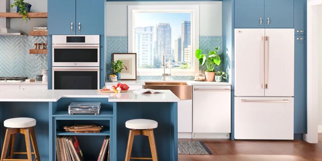 front view of a modern kitchen with blue cabinetry and white appliances