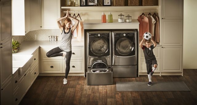 Credit: LG Front view of a modern laundry room with an LG washer and dryer and a mom and son doing yoga poses