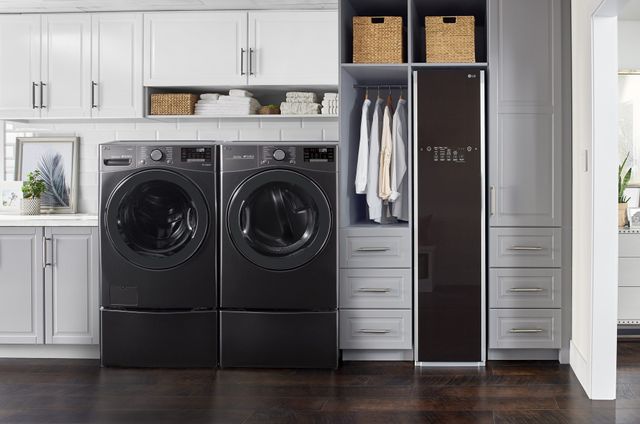 front view of a modern laundry room with an LG washer, dryer, and steam closet