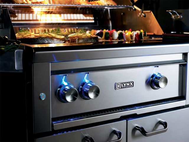 Close view of veggies cooking on an opened Lynx gas grill.