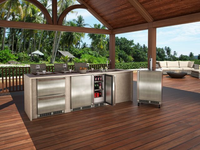 Front view of a modern outdoor kitchen on a wood patio with various outdoor refrigerators