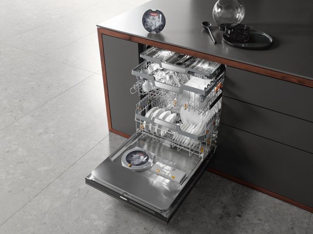standing view over an opened fully loaded Miele dishwasher in a contemporary kitchen