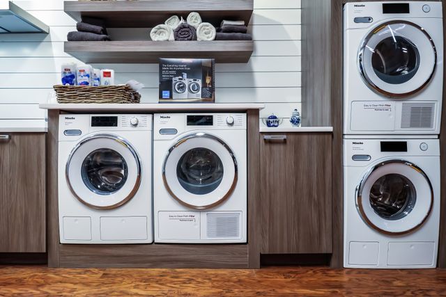 Credit: Miele Front view of a large laundry room with two Miele washers and dryers
