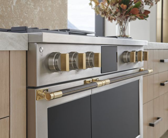 Close view of a brass-knobbed Monogram 48" range
