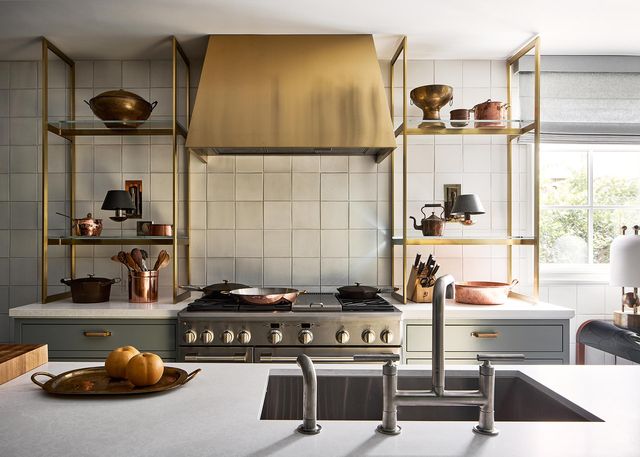 Front view of a modern kitchen with a Monogram 48" range and a gold range hood