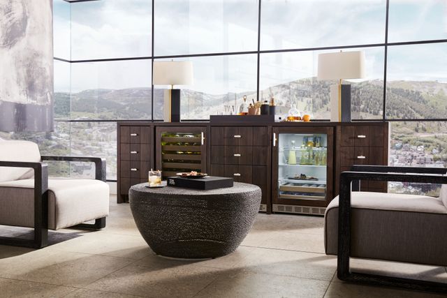 front view of a luxury living room with a server bar containing a wine cooler and mini fridge in front of a large window wall