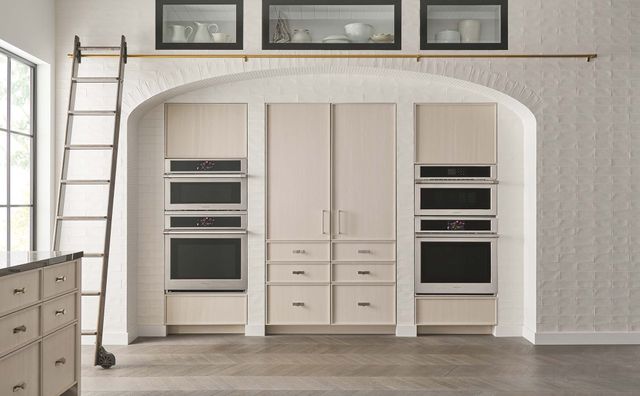 Front view of a modern kitchen with a Mongram frennch door refrigerator and a double wall oven on both sides