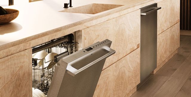 View of a modern kitchen with a Monogram stainless steel dishwasher slightly opened.