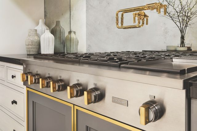 Close view of a GE Monogram Statement range with brass accents.