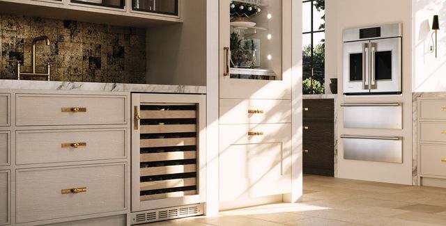 Front view of a warm toned kitchen with Monogram appliances and a Monogram under the counter wine cooler