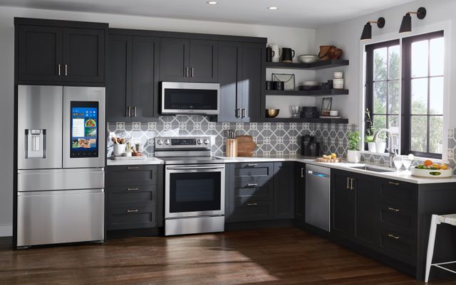Front view of a modern kitchen with black cabinetry and stainless steel Samsung appliances.