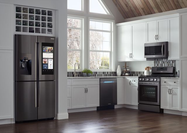 Front view of a modern kitchen with a Samsung appliance suite and four door refrigerator