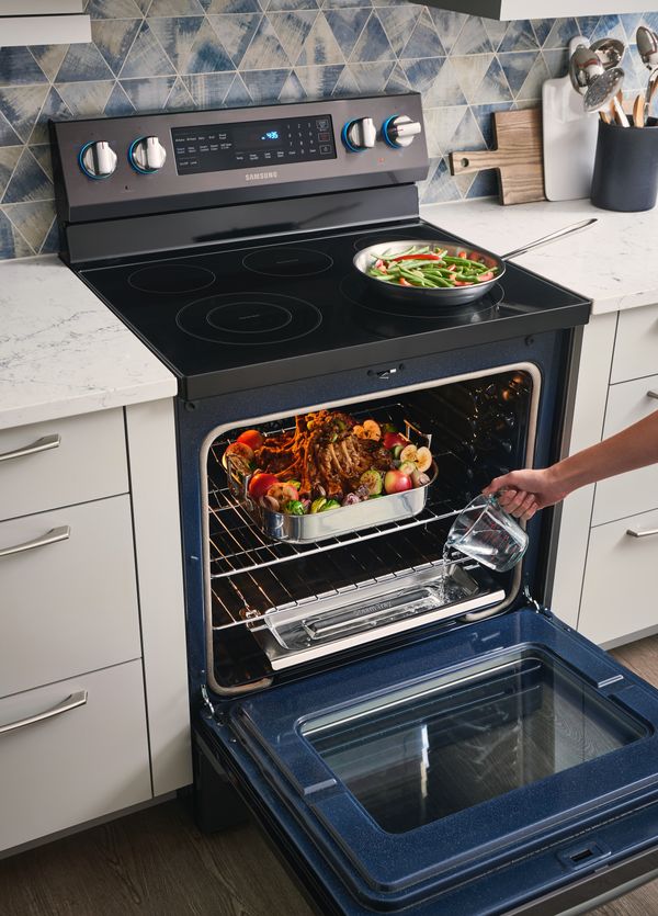 Samsung electric stove with food cooking and oven door open