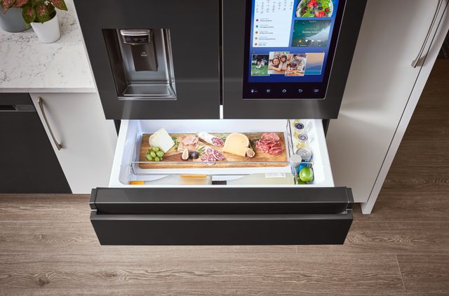 Front view of a Samsung refrigerator with water pitcher, smart hub, and drawers.
