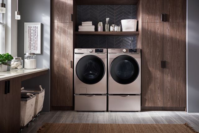Front view of a champagne colored washer and dryer from Samsung in a modern laundry room