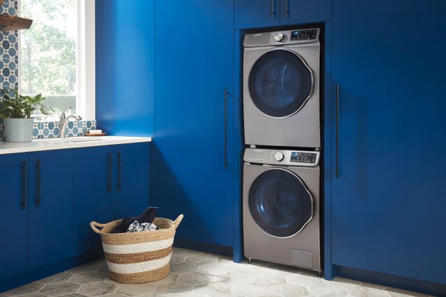Front view of a Samsung stackable washer and dryer pair built into a blue wall of cabinetry