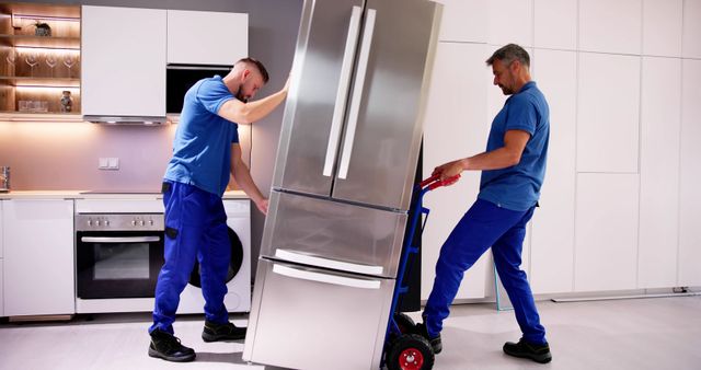front view of two men moving a refrigerator into a modern kitchen