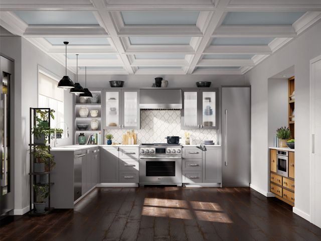 front view of a modern kitchen with white walls, white cabients, and stainless steel Signature Kitchen Suite appliances throughout