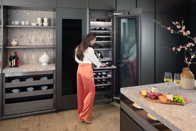 front view of a woman opening her Signature kitchen suite wine cooler