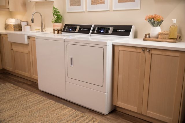 front view of a transitional laundry room with a speed queen washer and dryer