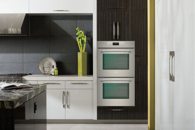 Front view of a modern kitchen with a Thermador double wall oven built into black cabinetry