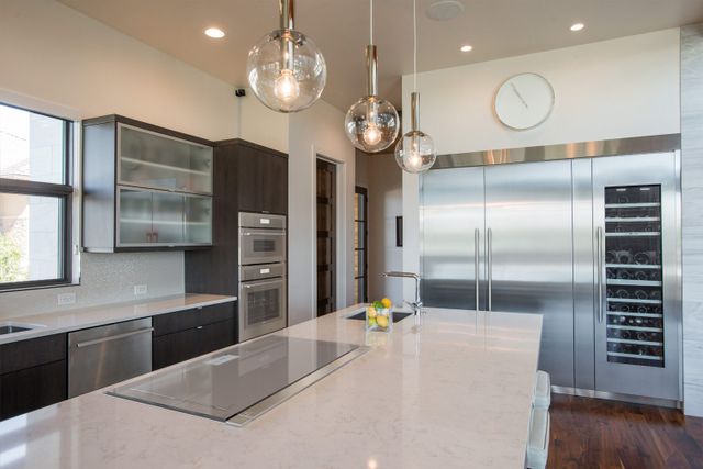 front view of a modern kitchen with white walls and stainless steel Thermador appliances