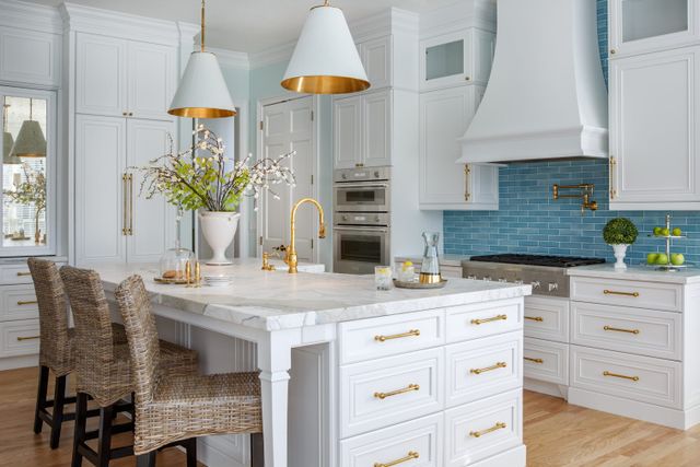 front view of a modern kitchen with white cabinetry and stainless steel Thermador appliances including a Thermador range top
