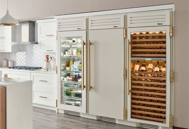 Front view of a modern kitchen with three True Residential refrigerators
