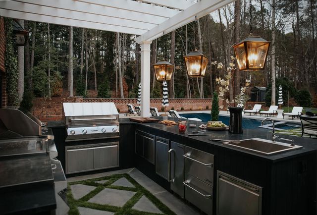 Front view of an outdoor kitchen with stainless steel Twin Eagles appliances with a fridge and sink