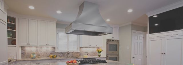 view of a vent a hood island range hood over kitchen island in a modern kitchen