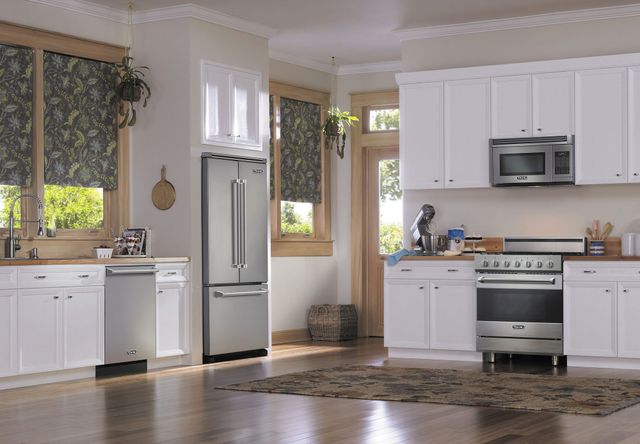 front view of a modern kitchen with white cabinets and stainless steel viking appliances including a dishwasher, refrigerator, microwave, and induction range.