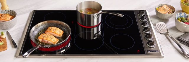 view of a viking 36" cooktop with fish and potatoes cooking 