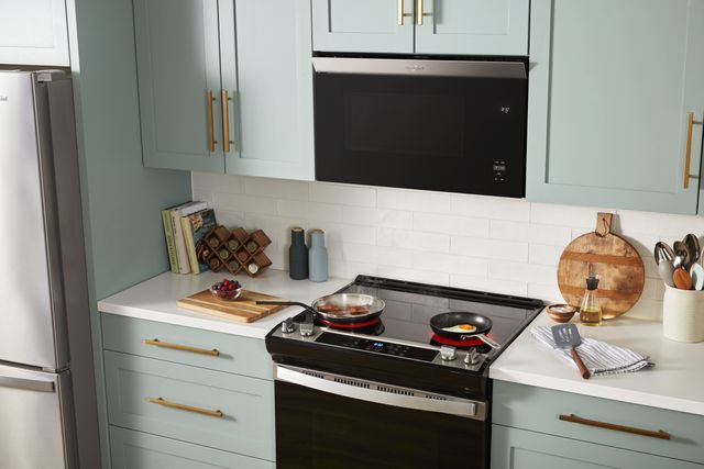 Front view of a modern kitchen with a Whirlpool range and over the range microwave