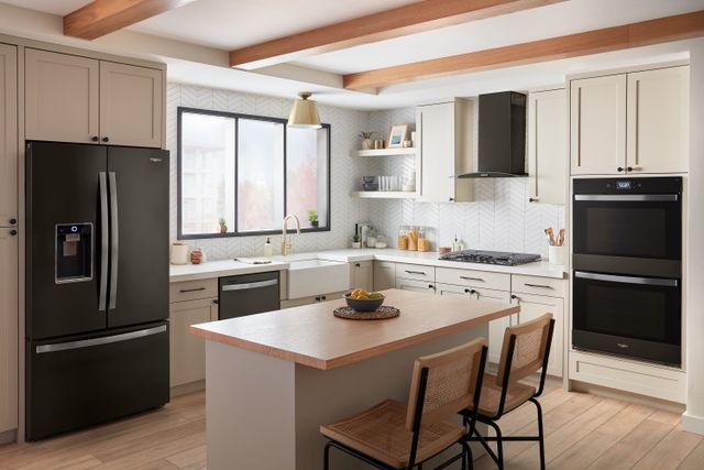 Front view of a modern kitchen with black stainless steel Whirlpool applainces