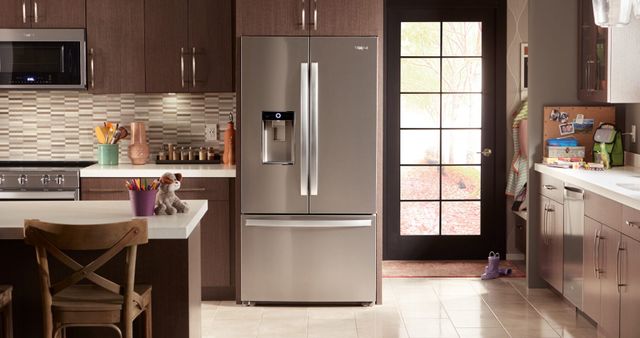 Front view of a modern kitchen with a Whirlpool french door refrigerator