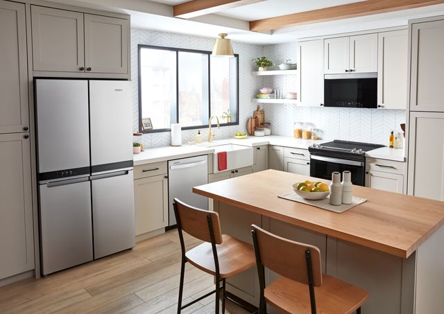 front view of a modern kitchen with a stainless steel whirlpool four door french door refrigerator 