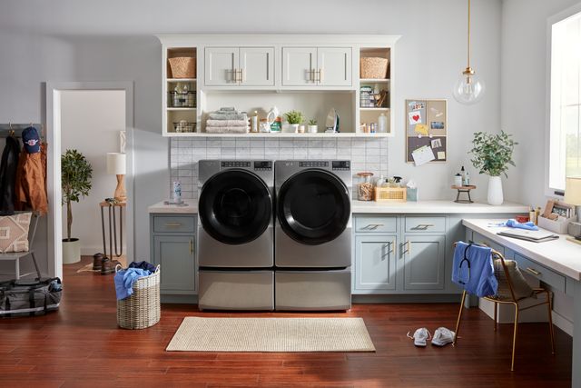Front view of a modern laundry room with a Whirlpool washer and dryer on pedestals
