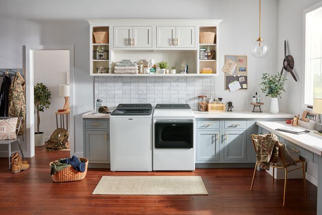 front view of a whirlpool white top load washer and dryer in a modern laundry room