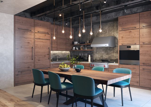 front view of a showroom with sub-zero, wolf, and cove appliances throughout and natural wood cabinetry with a dining table in the center and emerald chairs surrounding it