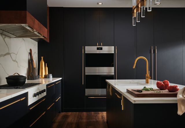 front view of a modern kitchen with blue cabinetry and a stainless steel built in Wolf double oven