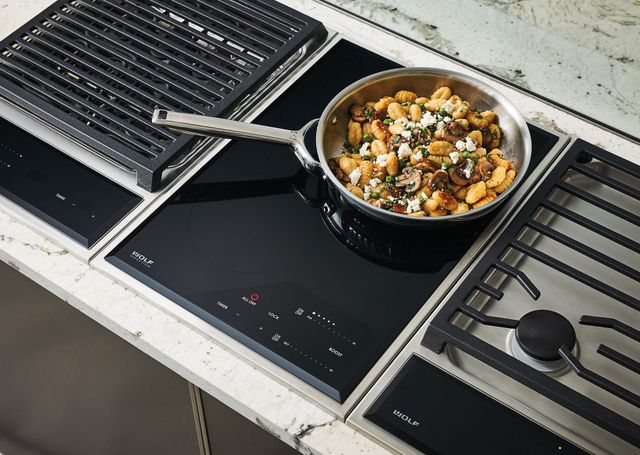 Close view of a Wolf induction cooktop with gnocci cooking in a pan on top
