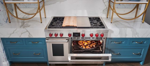 front view of a large Wolf gas range with the oven slightly opened