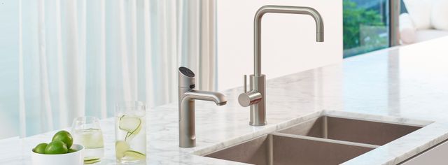 Front view of a dual kitchen sink with two luxury kitchen faucets in a modern kitchen