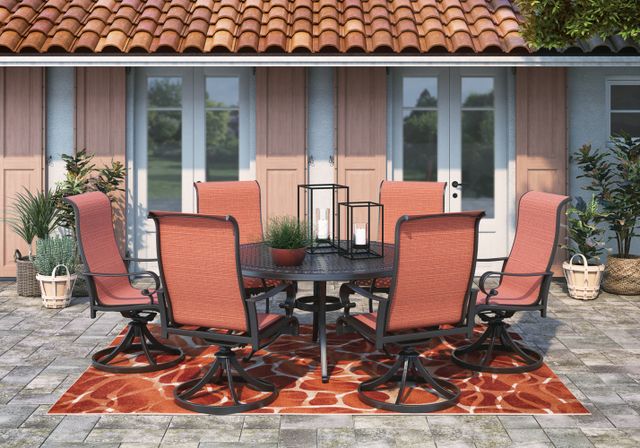 Front view of a modern California backyard patio with a metal and fabric table and chairs
